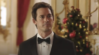 Will Kemp in front of a Christmas tree in Hallmark's My Sweet Austrian Holiday