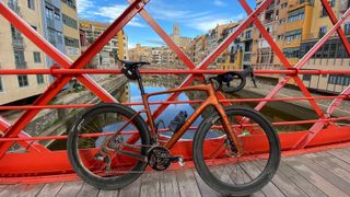 Bike on bridge in Girona with river and buildings behind