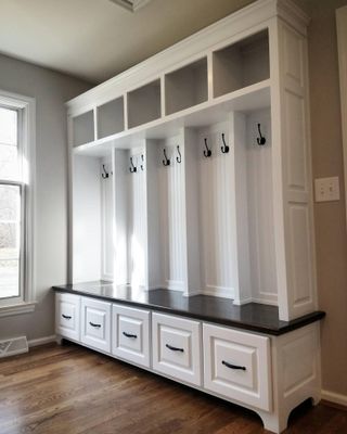 A mudroom with locker style storage and wood flooring