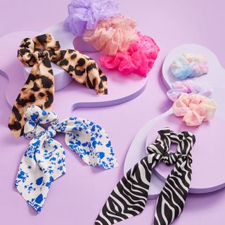 Superdrug Studio London Zebra Print Short Scarf Scrunchie and other scrunchies on a purple surface