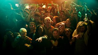 Phillip stands in a crowd of people partying in Black Mirror