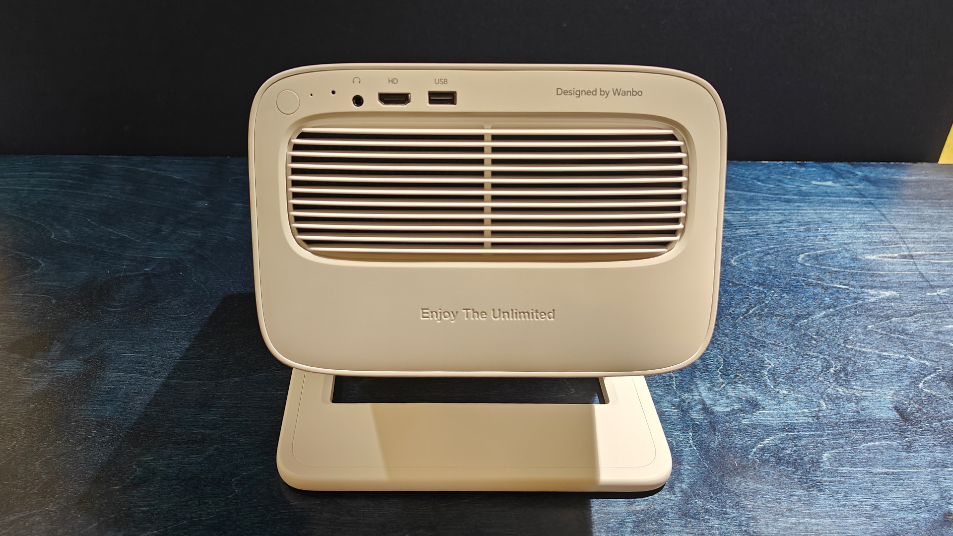 Wanbo Vali 1 home cinema projector on black wood grain surface showing rear of projector