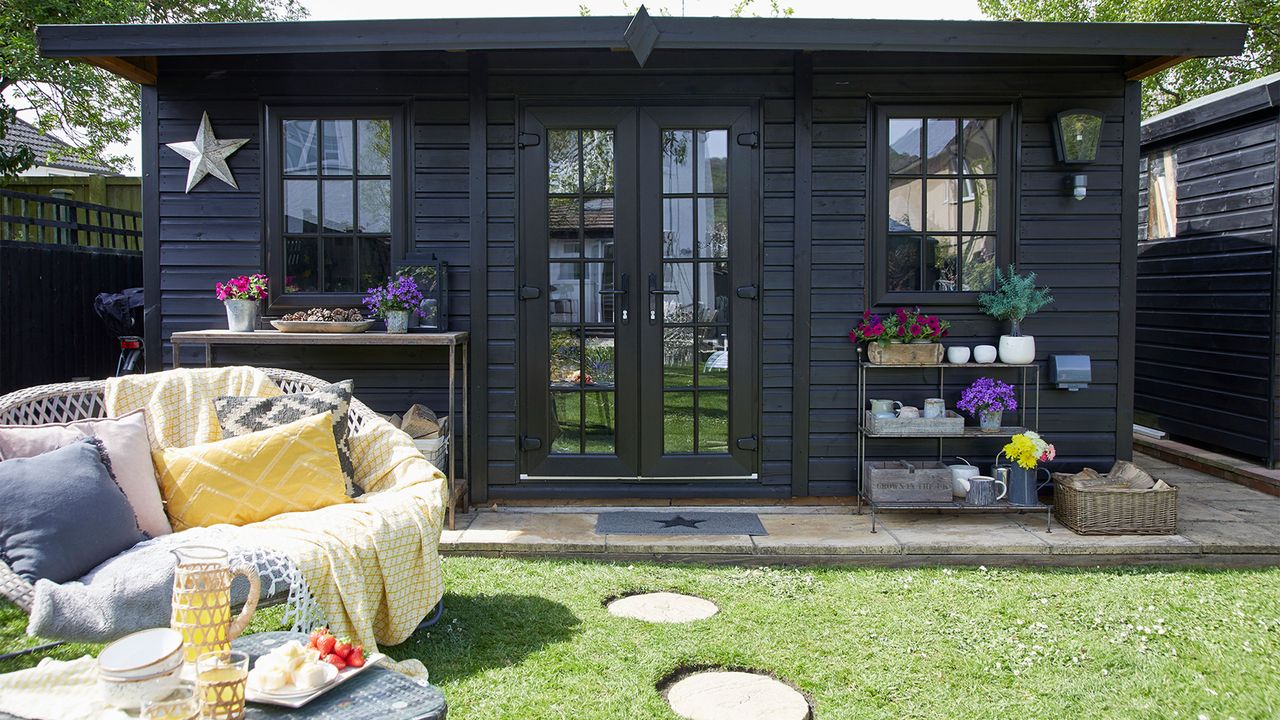 black painted summerhouse on concrete slabs