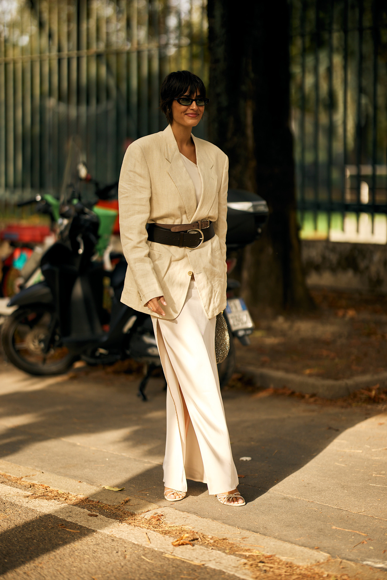 woman wearing a blazer, double belts, and trousers