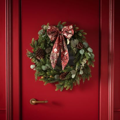 Red door with wreath with red bow