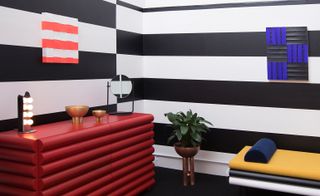 Conceptual hotel suite with black and white striped wall and colorful furniture