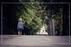 Little boy walking down a path alone