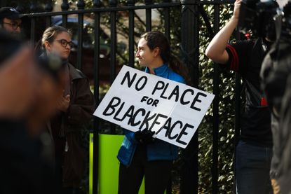 A protester holding a sign against blackface