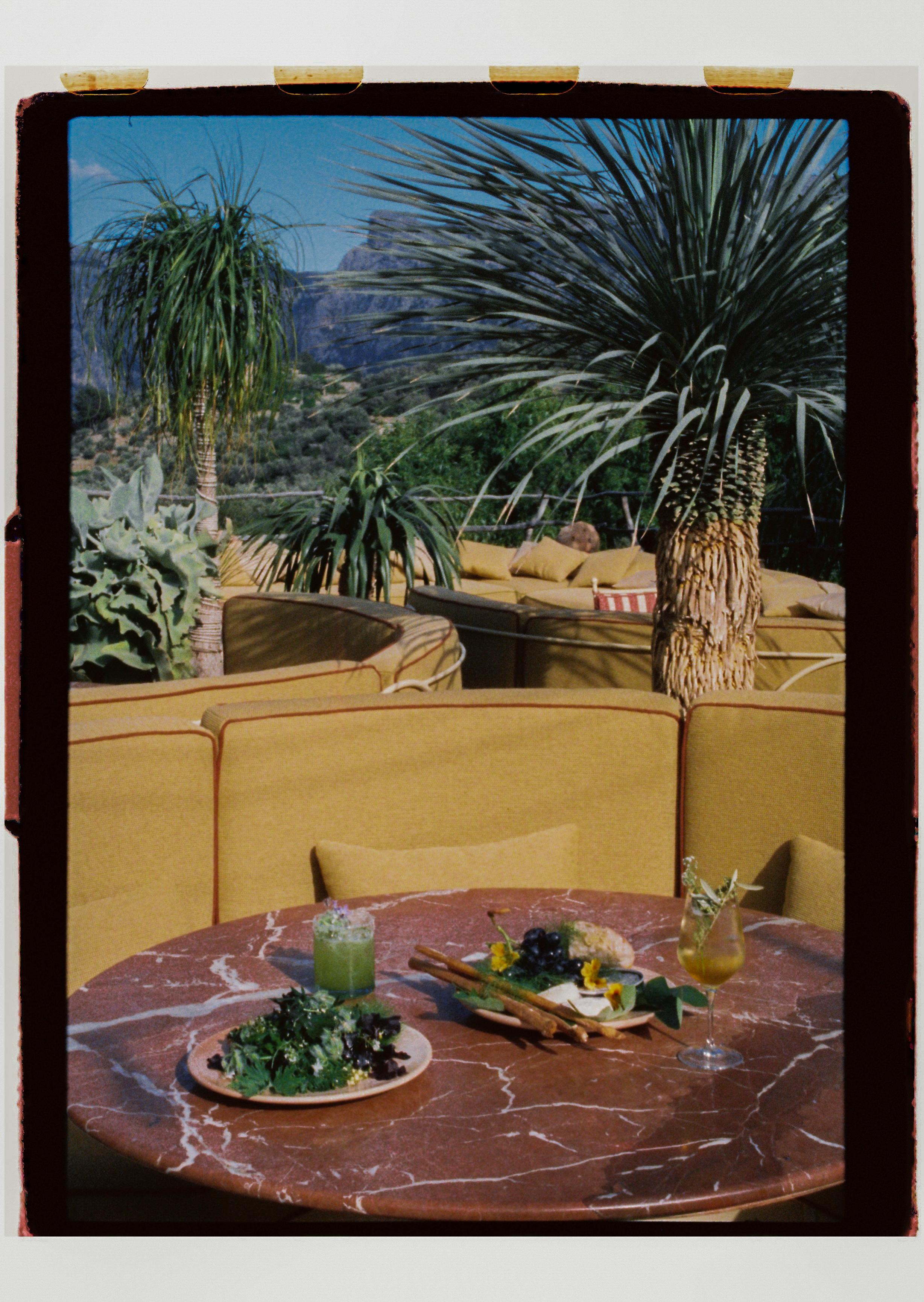 upholstered seating, tables and steel frame chairs on sunny terrace restaurant