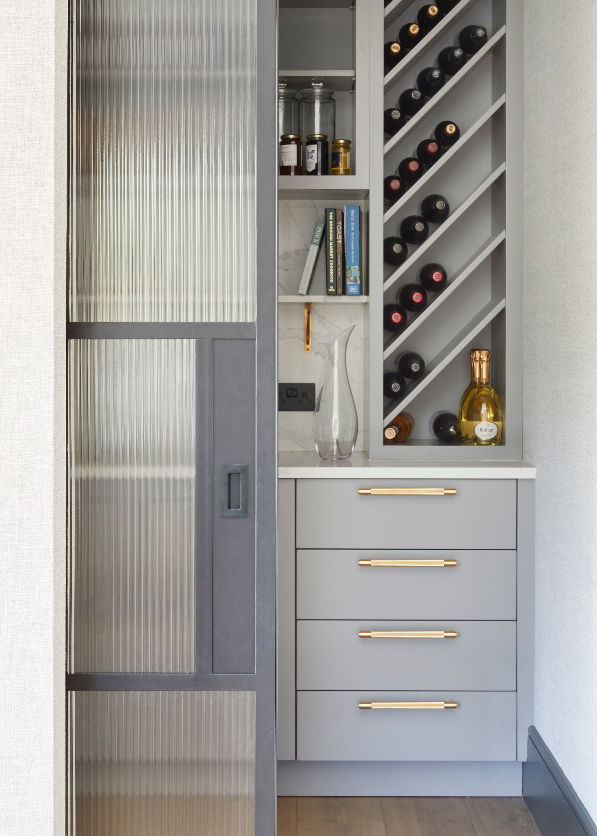 integrated grey cabinetry behind a glass door