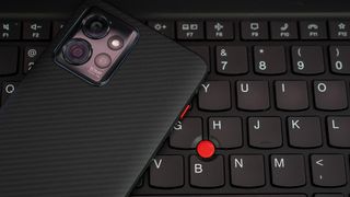 The Red Key on the ThinkPhone by Motorola on the keyboard of a Lenovo ThinkPad Carbon X1 laptop