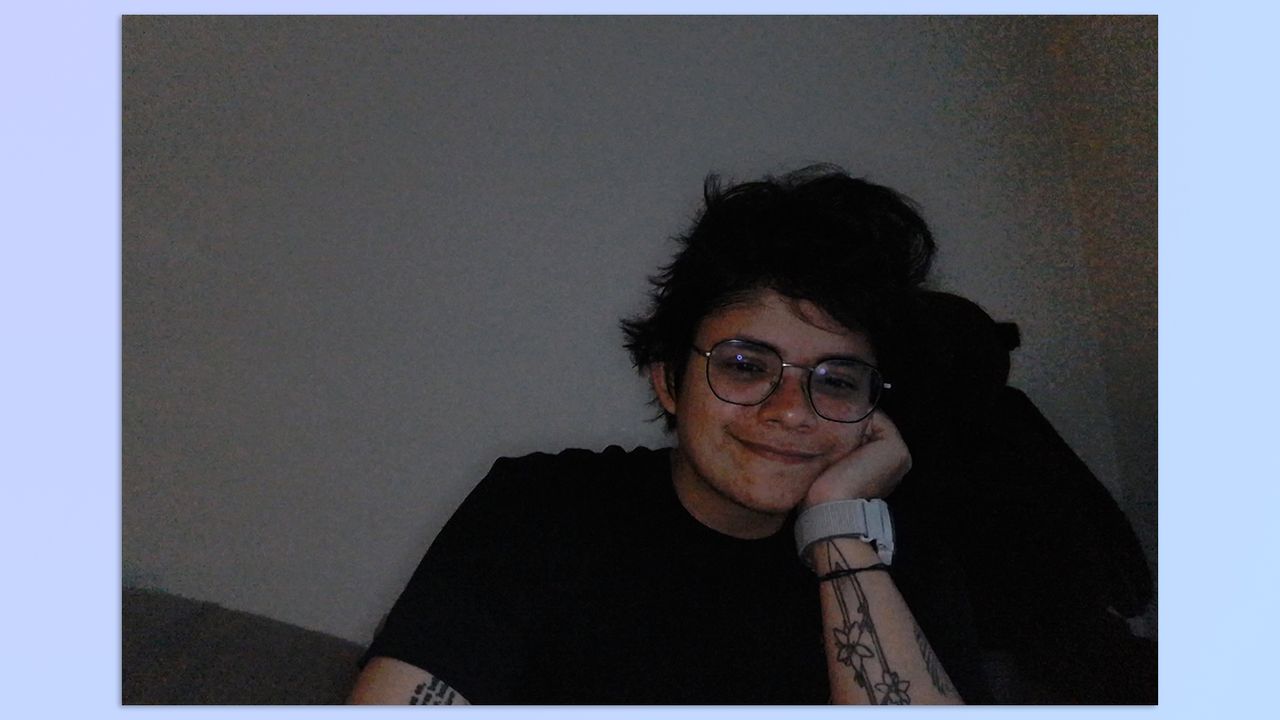 A photo of a person sitting on a couch, taken with a Razer Kiyo webcam (with ring light on low brightness)