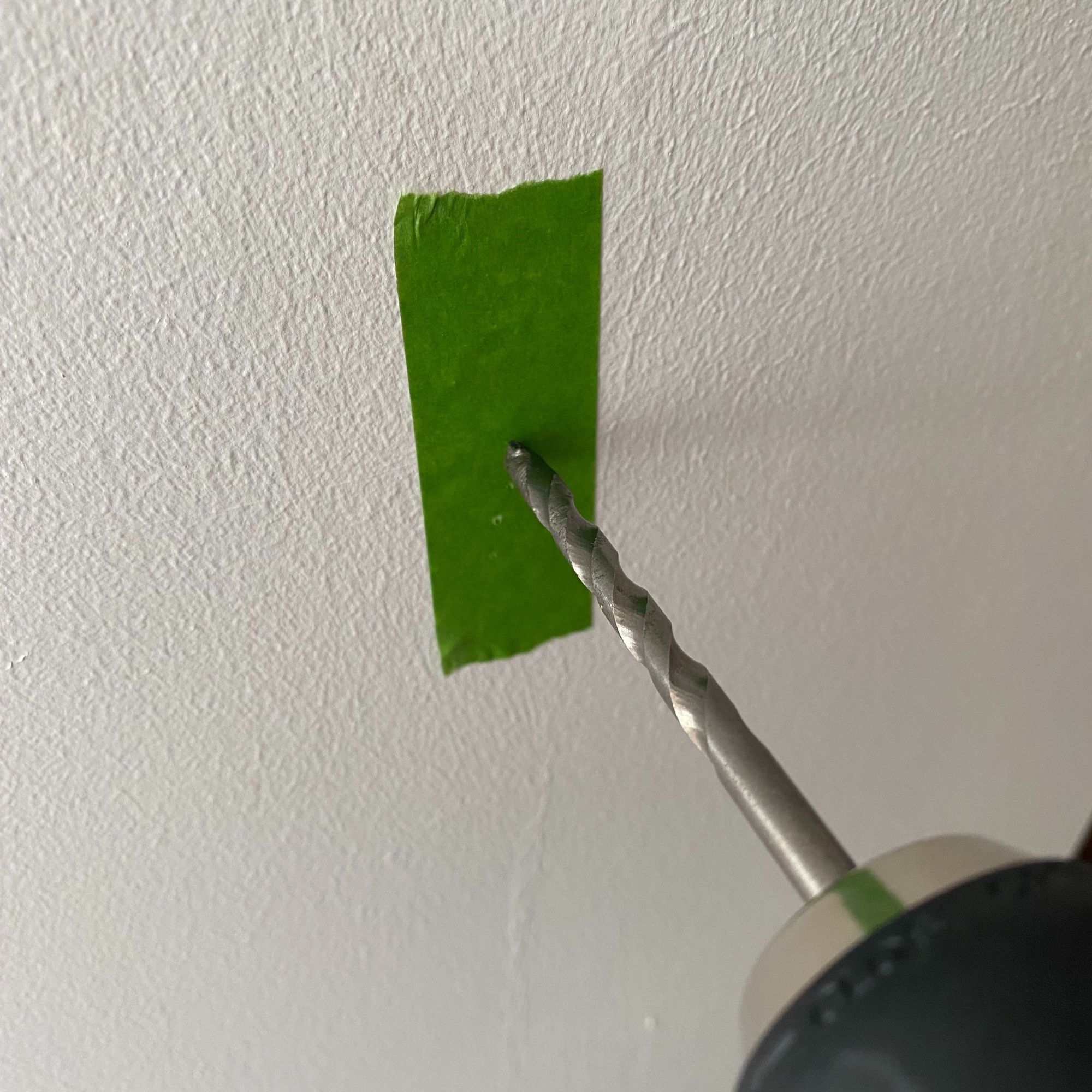 Piece of masking tape applied to a wall to prevent paint cracking when drilling a hole