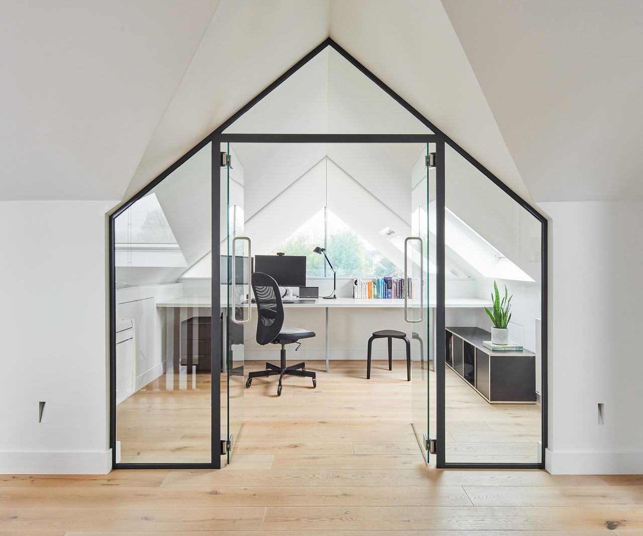 A home office in the loft space in a bungalow with glass interior doors