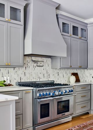 Traditional kitchen with gray cabinets and ventilation hood