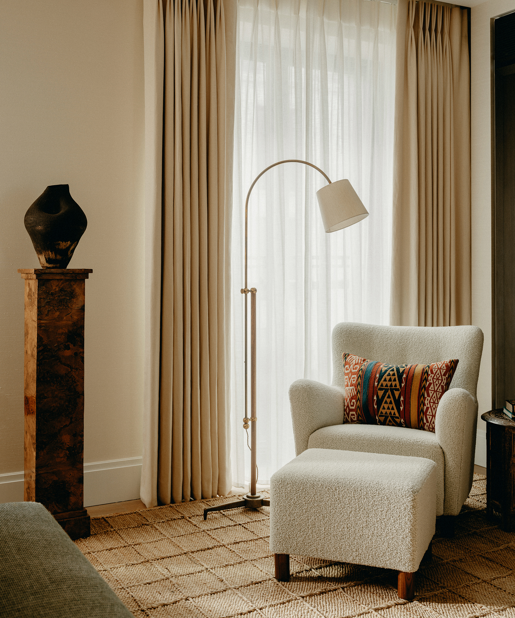 living room with jute rug under a white armchair