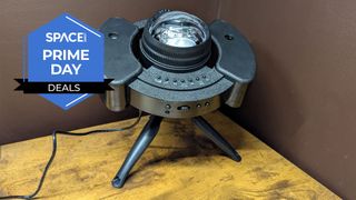 A black round object with a bulb coming out of the top is standing on a stand on a brown wooden surface with the Space.com logo in the top left corner.