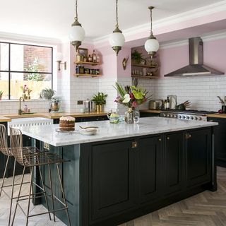 kitchen with marble worktop with metro tiles and cake on plate with cabinets