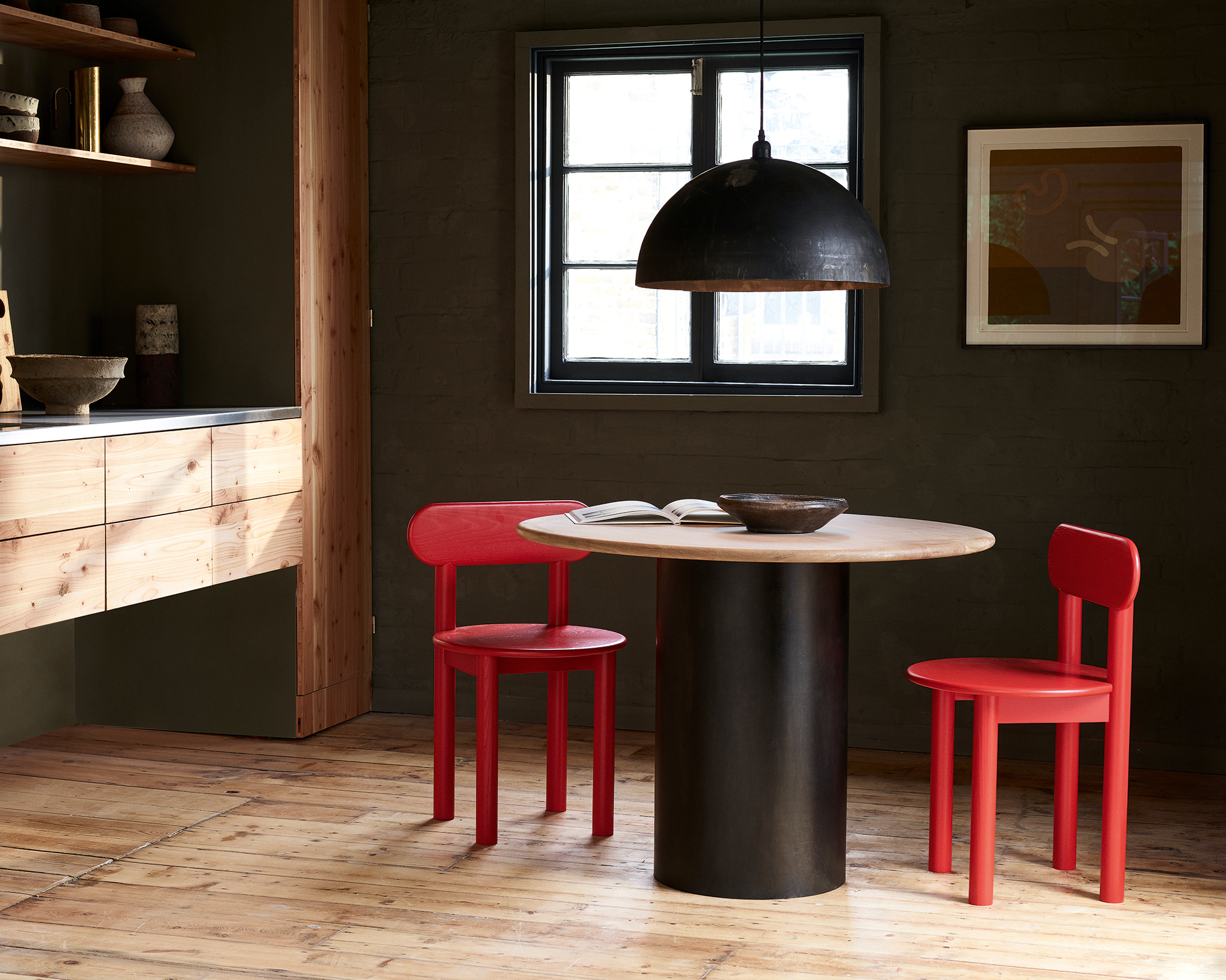round wood dining table with red wood chairs