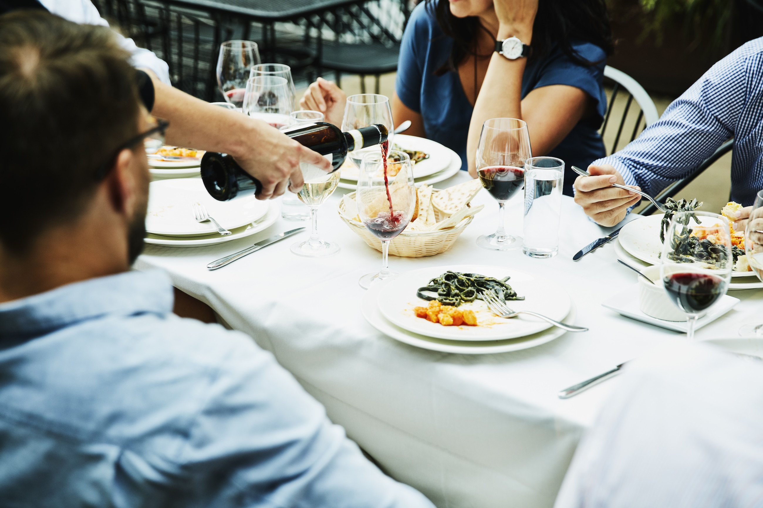 people eating and being served wine