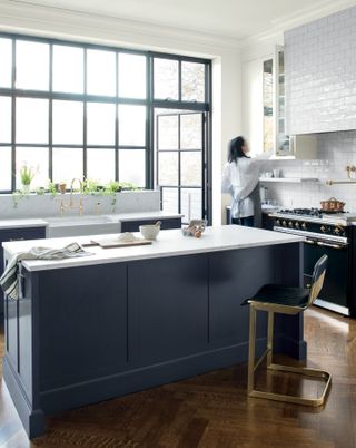 A kitchen with cabinets painted dark blue