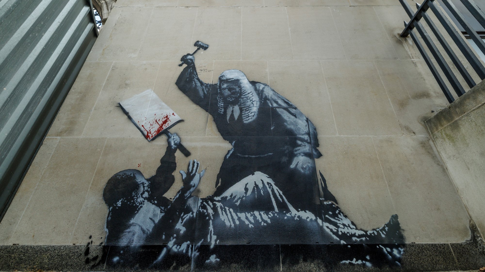 A Banksy mural outside the Royal Courts of Justice shows a judge beating a protester with a gavel