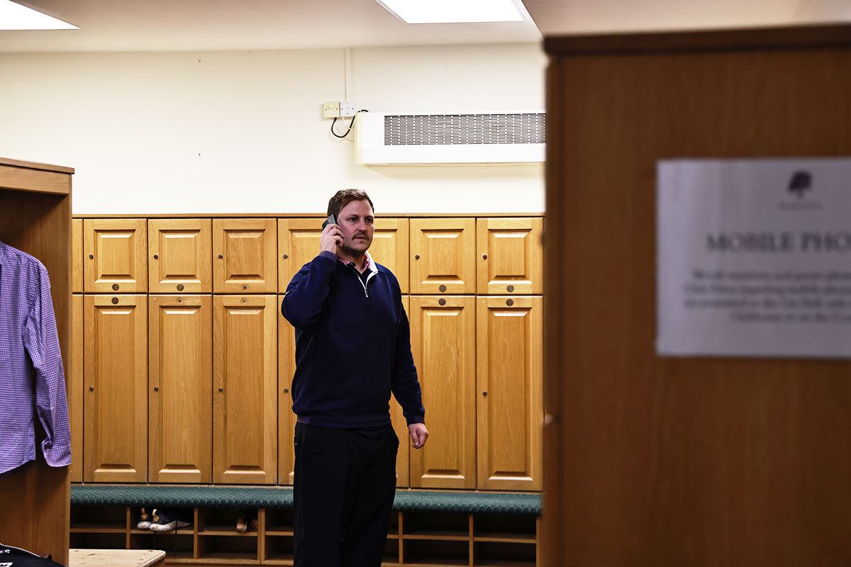 Nick Bonfield in the locker room at a golf club having a conversation on his mobile phone