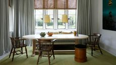 banquette seating in a window bay with oval dining table and timber chairs