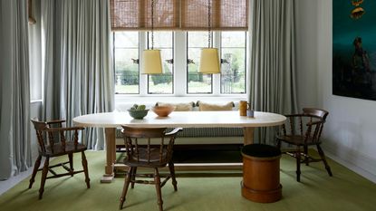 banquette seating in a window bay with oval dining table and timber chairs