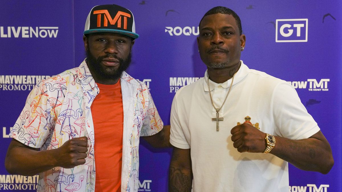 Floyd Mayweather and Don Moore pose at press conference.