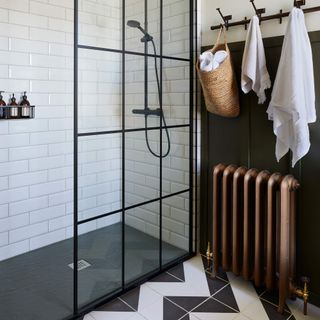 Black and white tiles floor in front of black framed shower