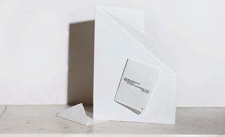 White marble mantelpiece, white invitation that opens into a sketched image, white envelope