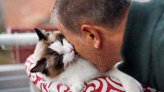 Man cuddling cat