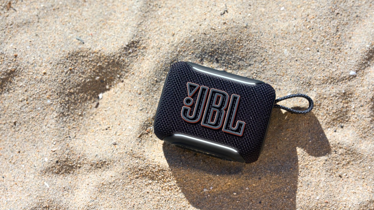 JBL Go 5 black Bluetooth speaker on some sand