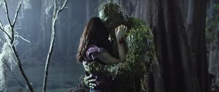 Swamp Thing and Abby Arcane embrace in a dark forest.