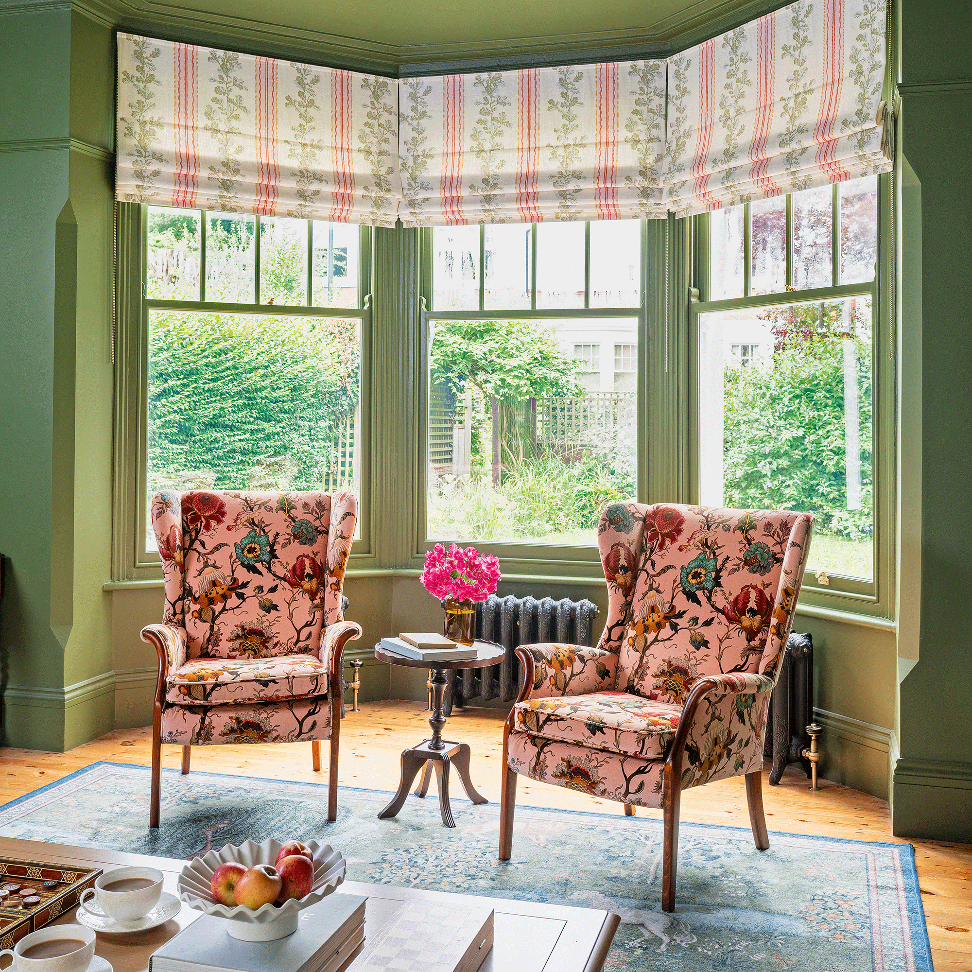 Green living room with pink armchairs