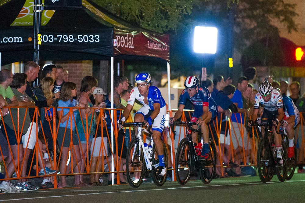 A UHC rider leads a 4 man break along the finishing stretch mid-way through the men's race. Shortly later, the break begins to appear disorganized and eventually absorbed by a chasing field.