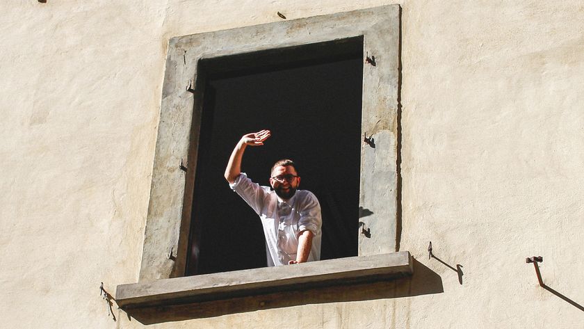 Augustinas Paukšte waving out of a window