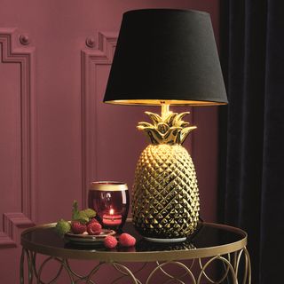 pineapple lamp with round table and black curtain