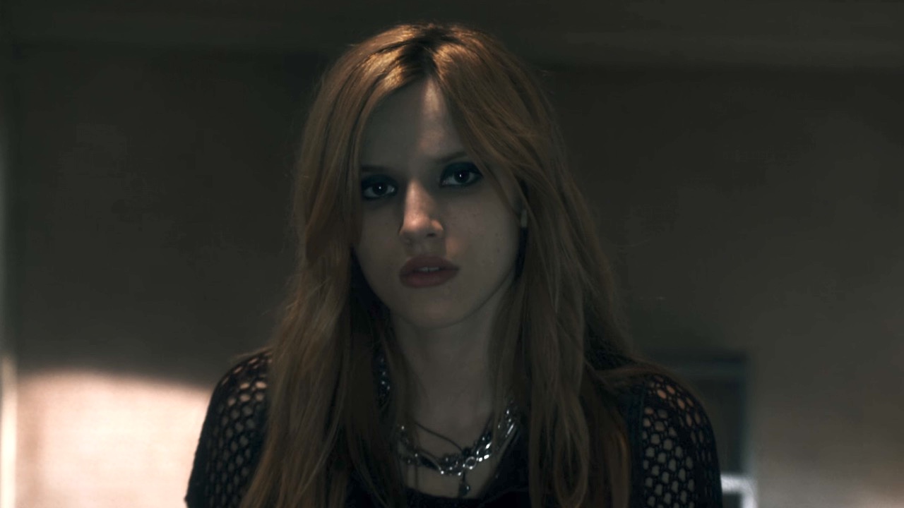 Bella Thorne looking out the window in Amityville: The Awakening