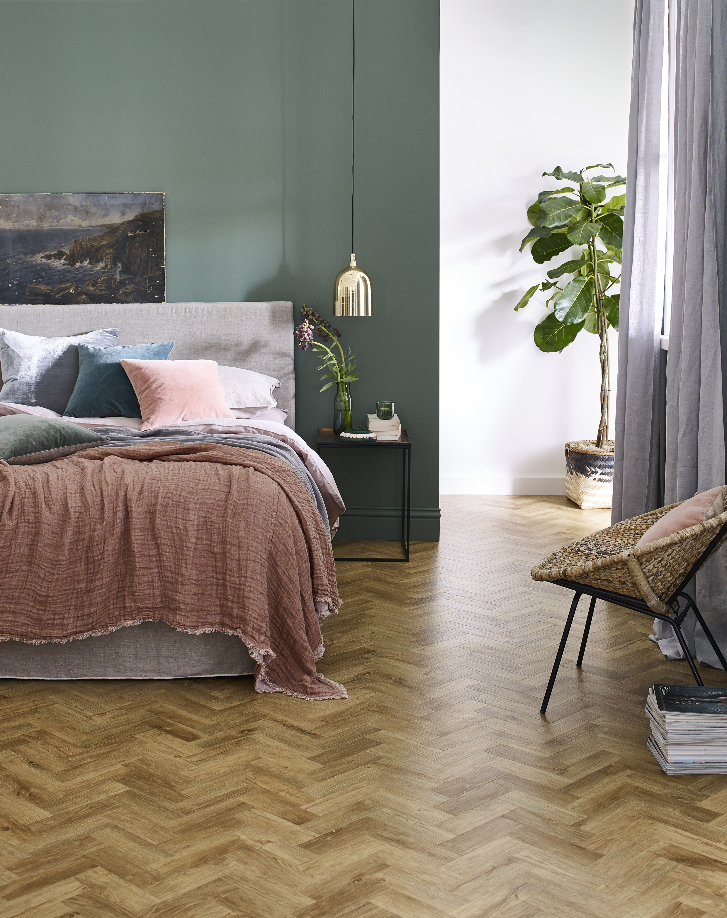 Bedroom with oak parquet-style LVT floor, bed, chair, and green walls