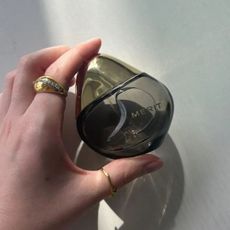 Junior beauty editor Grace Lindsay is holding the Merit Retrospect perfume