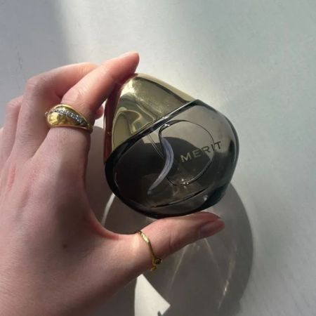 Junior beauty editor Grace Lindsay is holding the Merit Retrospect perfume