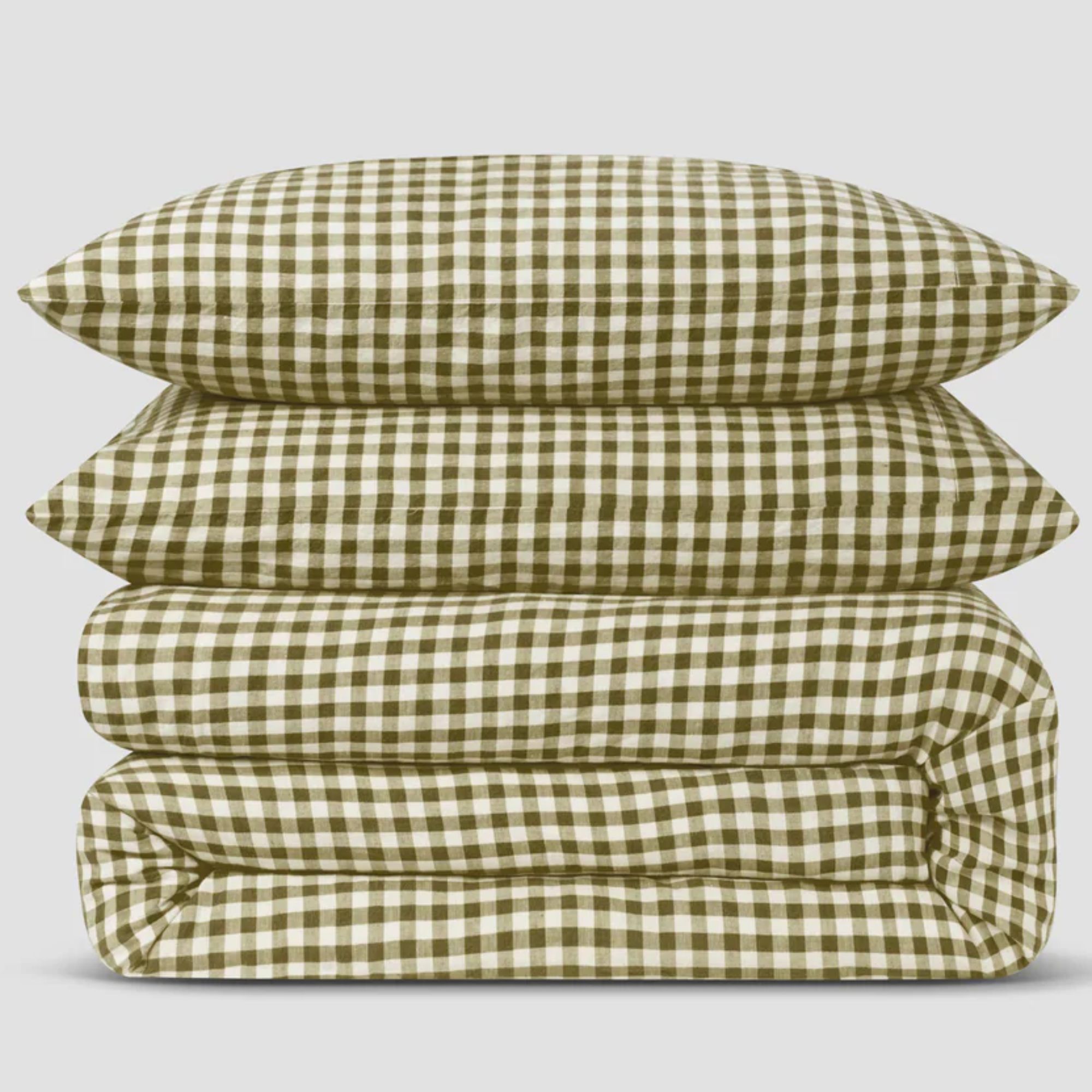 A folded and stacked Piglet in Bed green gingham duvet set