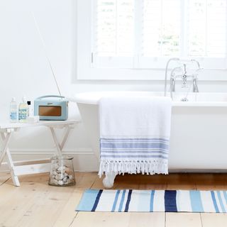 bathroom with white wall and bathtub and blue radio