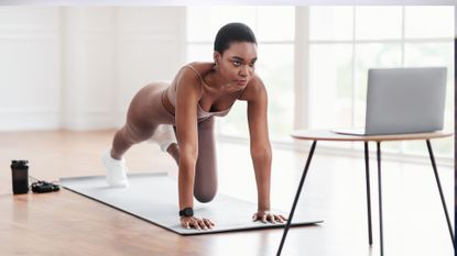 woman doing plank with knee raises