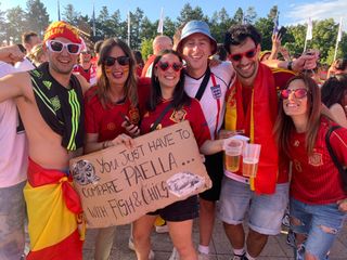 FourFourTwo's Ed McCambridge posed with Spain fans who are holding a sign saying "You just have to compare paella to fish and chips"