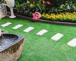 A neat paving stone path in a garden of artificial grass
