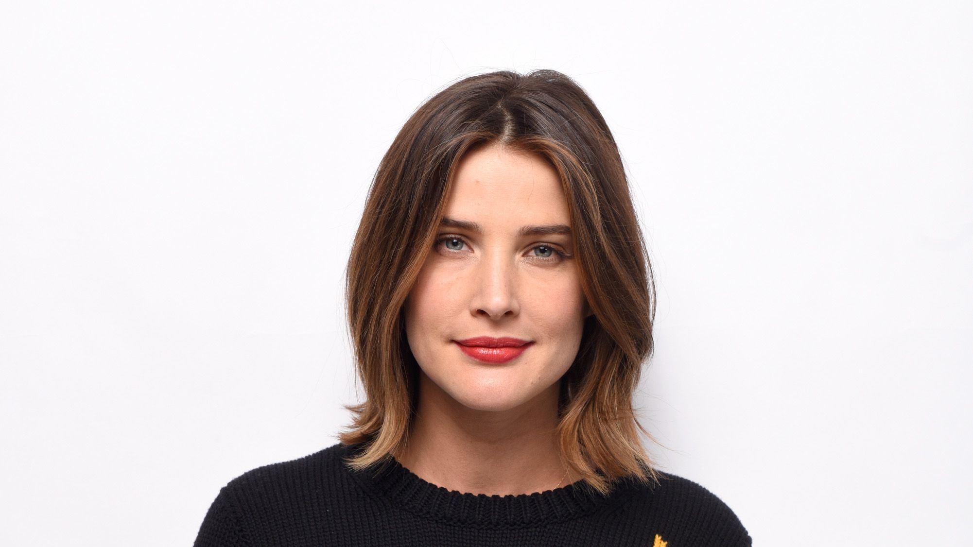 a headshot of actress colbie smulders with a brunette bob and wearing a black shirt