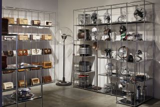 Artistic display of multiple vintage radios in a room on metalic silver shelves